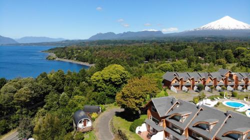 an aerial view of a resort with a lake and a mountain at Apart Hotel Sol y Lago in Pucón