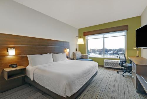 a hotel room with a bed and a large window at Holiday Inn Express & Suites - Collingwood in Collingwood