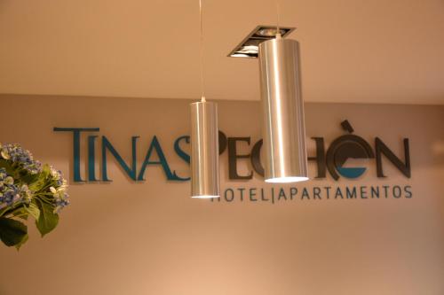 a chandelier hanging from a sign on a wall at Tinas de Pechon in Pechón