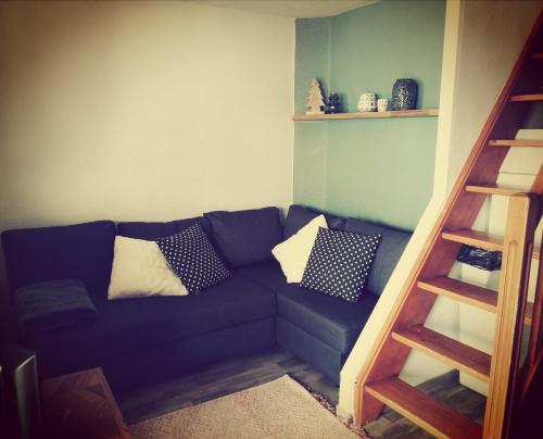 a living room with a blue couch with pillows at L'Ourson skis aux pieds in Valmeinier