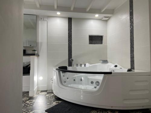 a white bathroom with a tub and a shower at LH Évasion loft pour 2 avec balnéo in Le Havre