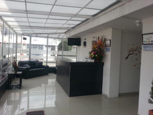 a lobby with a reception desk and a couch at Hotel Feria Nova in Bogotá
