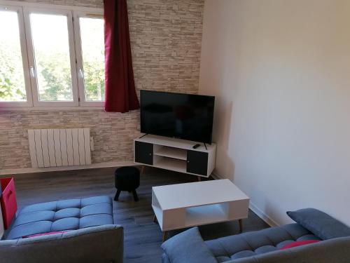 sala de estar con 2 sofás y TV de pantalla plana en Appartement meublé proche du futuroscope, en Poitiers