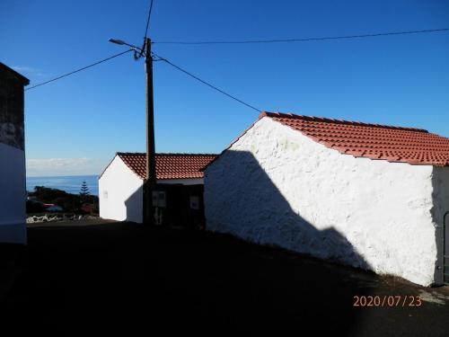a white building with a red roof at Adega Vermont in Biscoitos