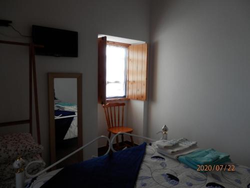 a bedroom with a bed and a window and a mirror at Adega Vermont in Biscoitos