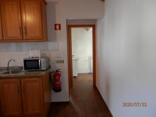 a kitchen with a red fire extinguisher in the doorway at Adega Vermont in Biscoitos