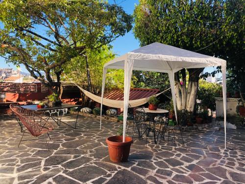 un patio con una tienda, sillas y una hamaca en Luna en Taxco de Alarcón