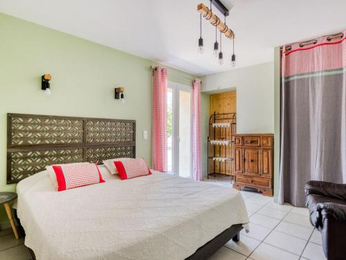 une chambre avec un grand lit avec des oreillers rouges dans l'établissement Holiday Home in Rasteau with Private Pool, à Rasteau