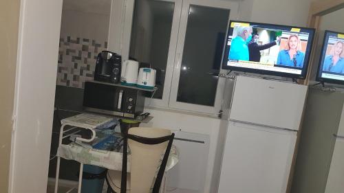 eine Küche mit einem TV auf dem Kühlschrank in der Unterkunft MAGNIFIQUE STUDIO in Saint-Just-Sauvage