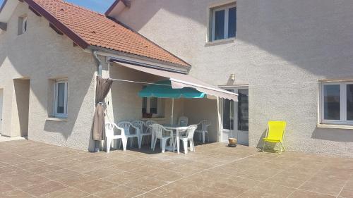 eine Terrasse mit einem Tisch, Stühlen und einem Sonnenschirm in der Unterkunft MAGNIFIQUE STUDIO in Saint-Just-Sauvage