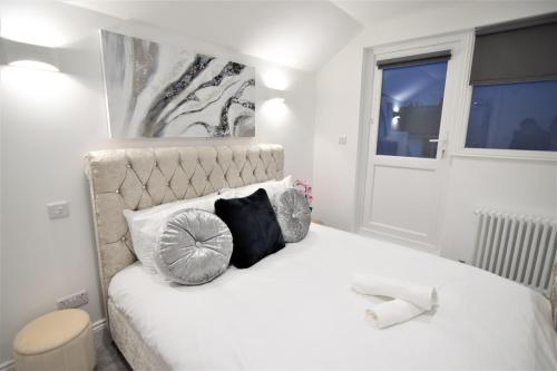 a white bed with two pillows and a phone on it at Two bedroom flat next ot brighton seafront sleep 6 in Brighton & Hove