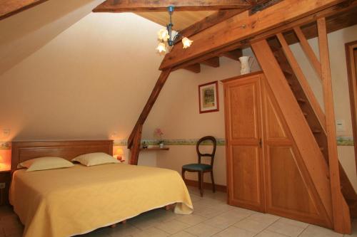 ein Schlafzimmer mit einem Bett und einem Holzschrank in der Unterkunft Chambres d'Hôtes Larnaudie in Saint-Amand-de-Coly