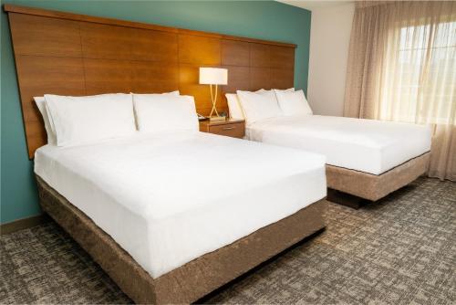 two beds in a hotel room with white pillows at Staybridge Suites - Nashville - Franklin by IHG in Franklin