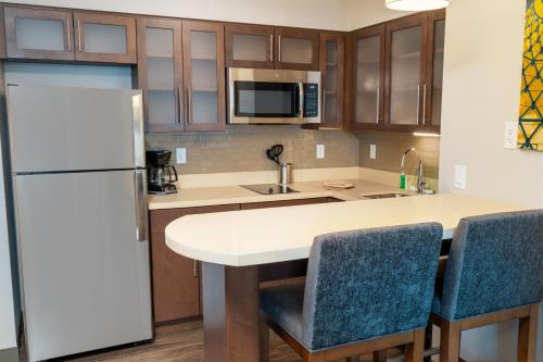 a kitchen with a refrigerator and a table with chairs at Staybridge Suites - Nashville - Franklin by IHG in Franklin