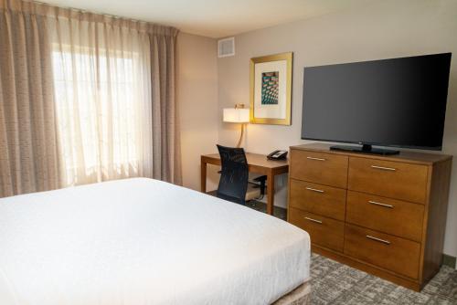 a hotel room with a bed and a flat screen tv at Staybridge Suites - Nashville - Franklin by IHG in Franklin
