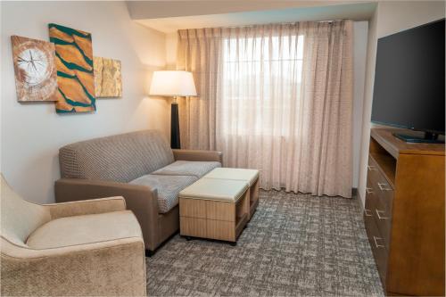 a living room with a couch and a chair and a tv at Staybridge Suites - Nashville - Franklin by IHG in Franklin