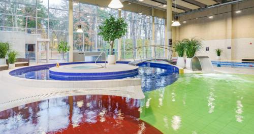 a large indoor swimming pool with a water slide at LaSpa in Laulasmaa