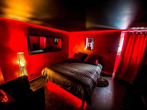een rode slaapkamer met een bed in een kamer bij Le rêve d’une nuit suite mystérieuse in Sarreguemines