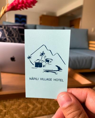 a hand holding a card with a drawing of a hotel at Napili Village Hotel in Kahana