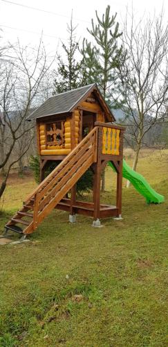 uma estrutura de brincar com um escorrega e um parque infantil em Fazenda Kosiv em Kosiv