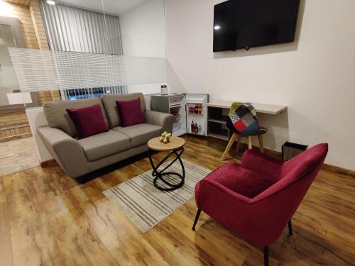 a living room with a couch and two chairs at Hotel Aristo Gold in Tunja