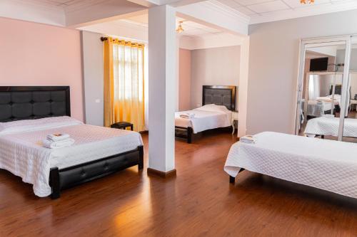 a bedroom with two beds and a mirror at Residencial Velia & Victoria in Cochabamba