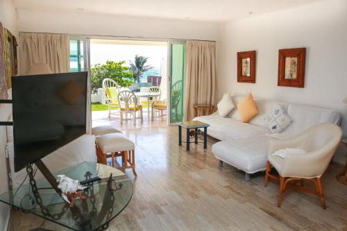 a living room with a couch and a tv at Brisas Shores Beach & OceanFront Apartments 1 or 2 bedrooms Cancun Hotel Zone in Cancún