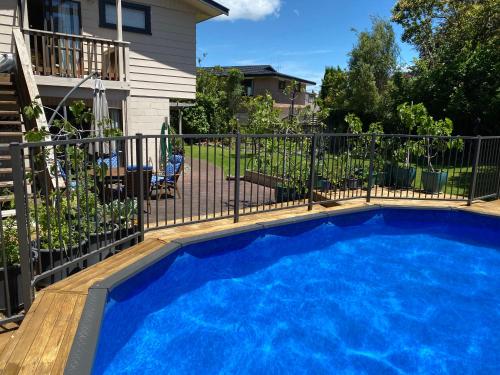 a swimming pool in front of a fence at Feel at Home in Tauranga
