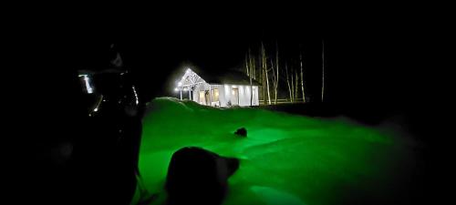a house with a green light in front of it at night at Brīvdienu māja ar Saunu in Saulkrasti