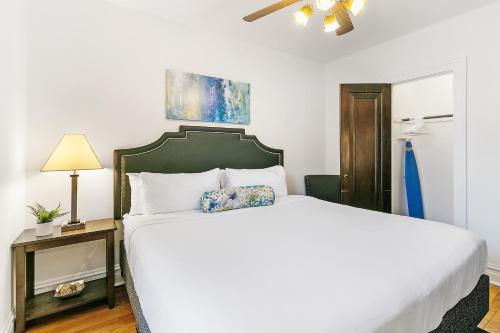 a bedroom with a white bed with a green headboard at Your 1BR Homey Haven in Vibrant Chicago - Larchmont 1A-3A in Chicago