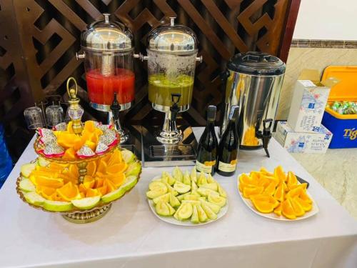 a table with three plates of fruit and a blender at THẢO AN HOTEL Huế in Hue