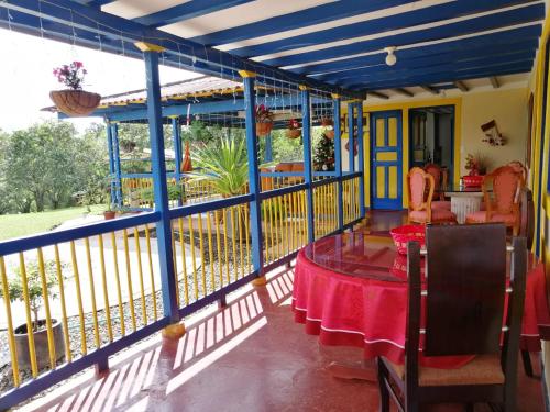 a balcony of a house with a table and chairs at Finca El Topacio Circasia-Quindio in Circasia