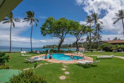 a pool at a resort with people playing in it at Napili Surf Beach Resort in Lahaina