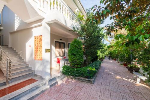 a courtyard of a building with stairs and trees at Quynh Mai Resort in Phu Quoc