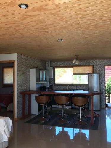 a kitchen with a bar with stools and a keyboard at vista al mar curanipe cabaña/casa in Curanipe