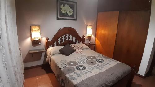 Un dormitorio con una cama con dos luces. en Cabaña Paso a Paso en Tandil