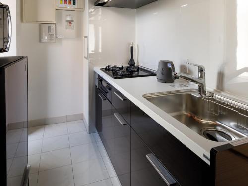 a small kitchen with a sink and a stove at Connect Inn Kyoto Station South in Kyoto