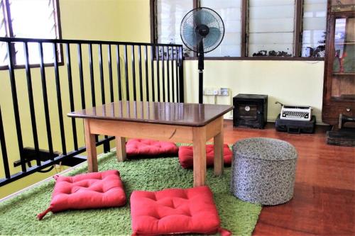 Habitación con mesa y sillas acolchadas de color rojo. en Once In Peninsula Guesthouse by Nestcove en Melaka