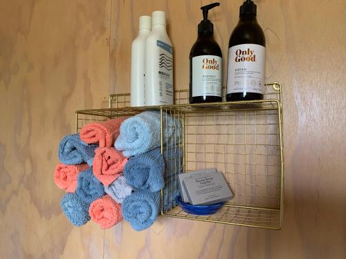 a metal rack with towels and bottles of wine at Fallow Hut in Masterton