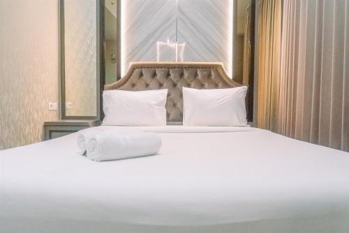 a large bed with white sheets and pillows at Classic Studio Room Apartment at Taman Melati Surabaya By Travelio in Surabaya