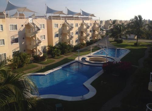 a swimming pool in front of a large building at Deep Ocean Acapulco in Acapulco