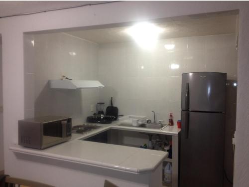 a kitchen with a microwave and a refrigerator at Deep Ocean Acapulco in Acapulco