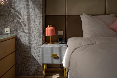 a bedroom with a bed and a lamp on a night stand at The Mercer in Hong Kong