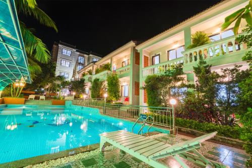 a hotel with a swimming pool at night at Quynh Mai Resort in Phu Quoc