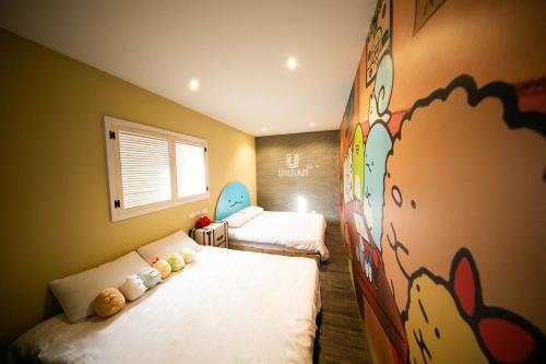 a bedroom with two beds and a mural on the wall at Urban in Kaohsiung