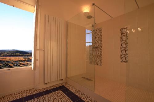 a bathroom with a shower with a glass door at La Maison R in Pignans