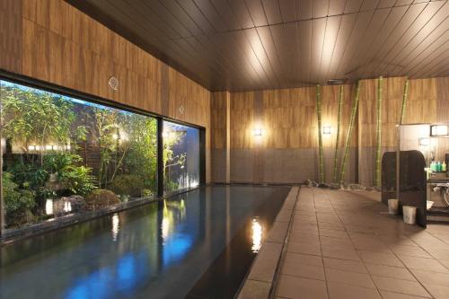una piscina en un edificio con una ventana grande en Hotel Route Inn Kusatsu Ritto -Ritto Inter Kokudo 1 gou-, en Ritto