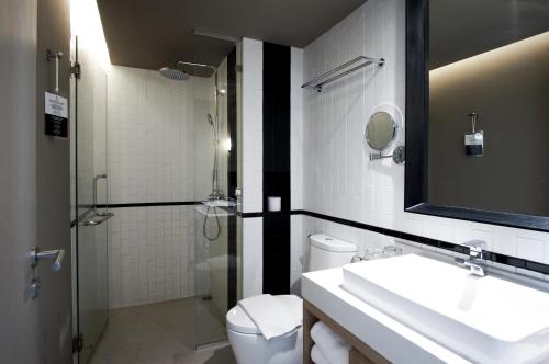 uma casa de banho com um lavatório, um WC e um chuveiro em Brique Hotel Chiangmai em Chiang Mai