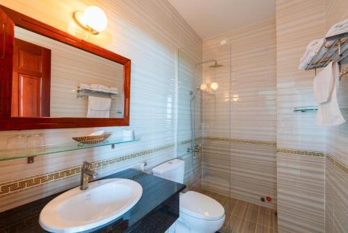 a bathroom with a sink and a toilet and a mirror at Quynh Mai Resort in Phu Quoc