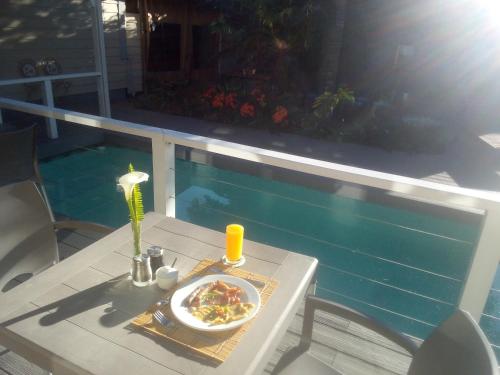 a table with a plate of food next to a pool at Victoria & Alfred Boutique Hotel in Port Elizabeth